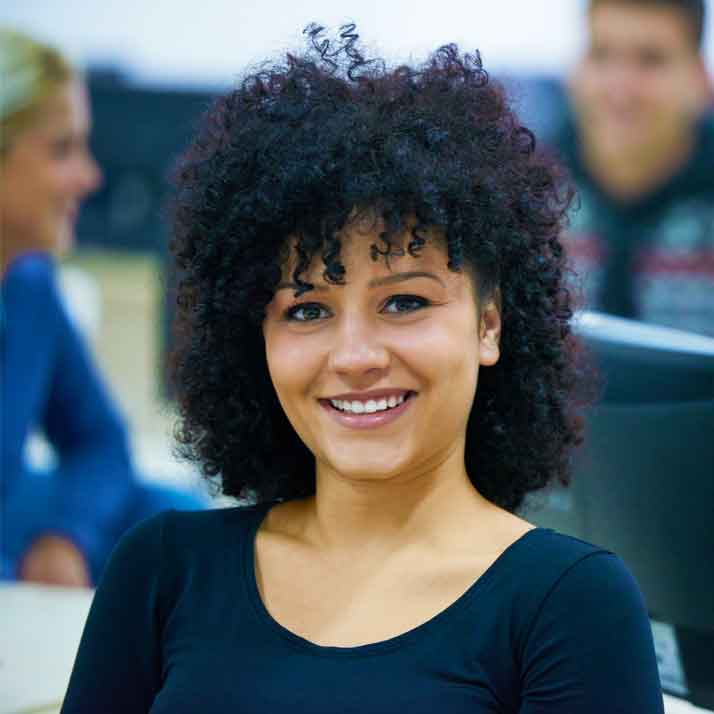 Female college student in class smiling and looking at viewer